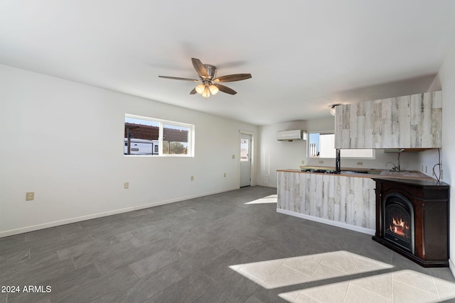 kitchen with a wall mounted air conditioner, ceiling fan, and a fireplace