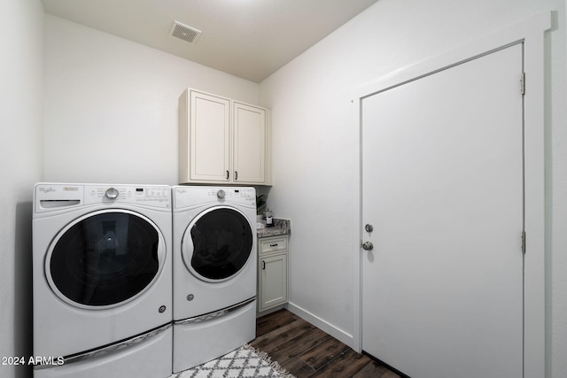 washroom featuring cabinets, dark hardwood / wood-style floors, and washing machine and dryer