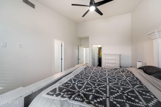 bedroom featuring ceiling fan and a high ceiling