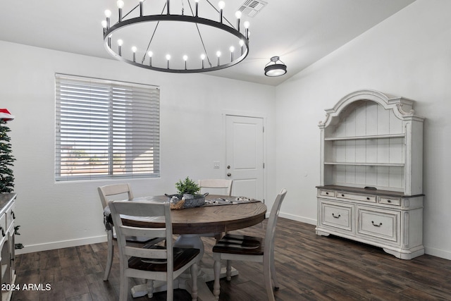 dining space with dark hardwood / wood-style flooring and an inviting chandelier