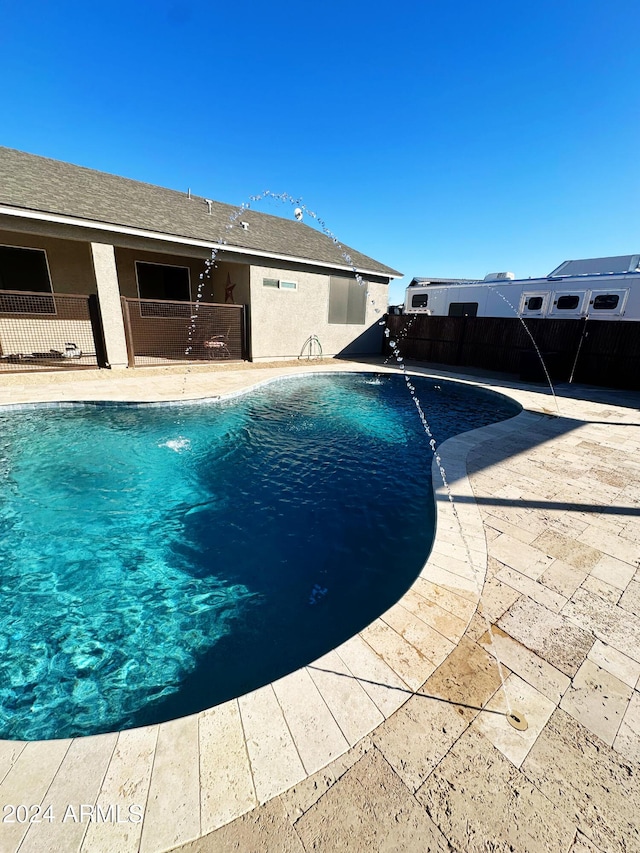 view of swimming pool featuring pool water feature and a patio