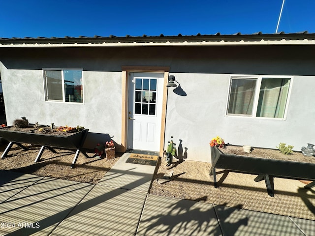 view of exterior entry featuring a patio