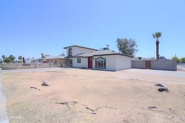 ranch-style home featuring fence and stucco siding