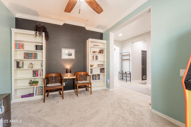 sitting room featuring crown molding, carpet floors, a ceiling fan, tile patterned floors, and baseboards