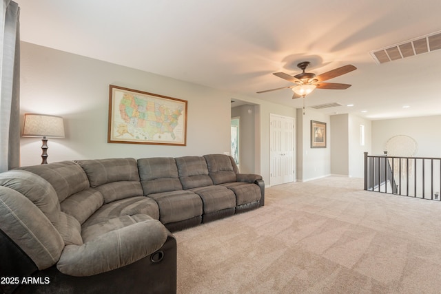 carpeted living room with a ceiling fan and baseboards