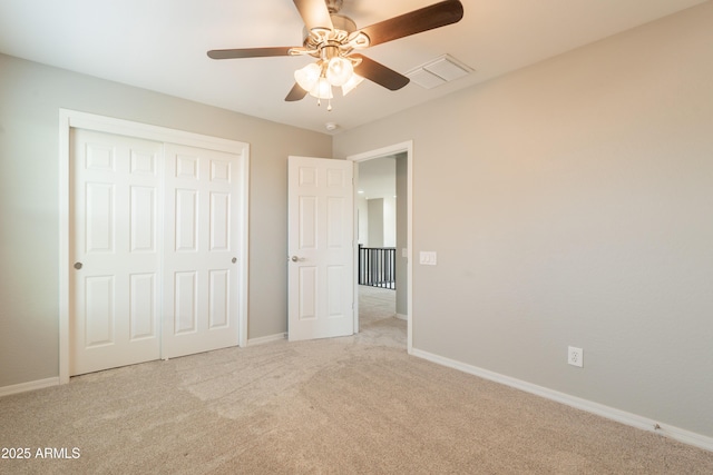 unfurnished bedroom with carpet floors, a closet, baseboards, and a ceiling fan