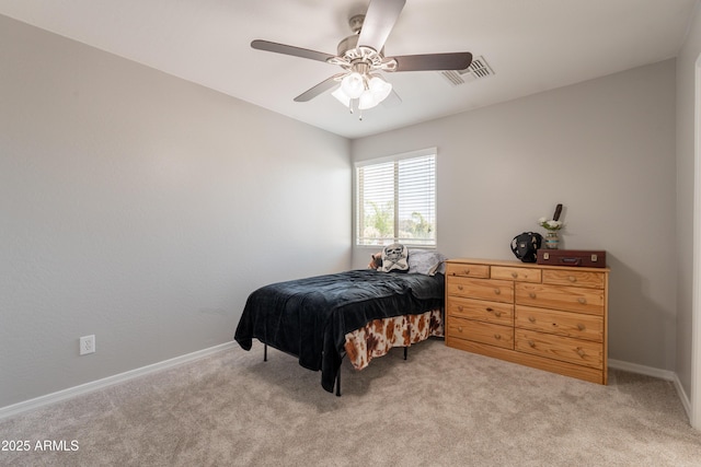 bedroom featuring light colored carpet, baseboards, and a ceiling fan