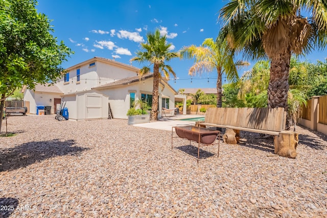 fenced backyard featuring a storage shed, an outdoor structure, and a patio area