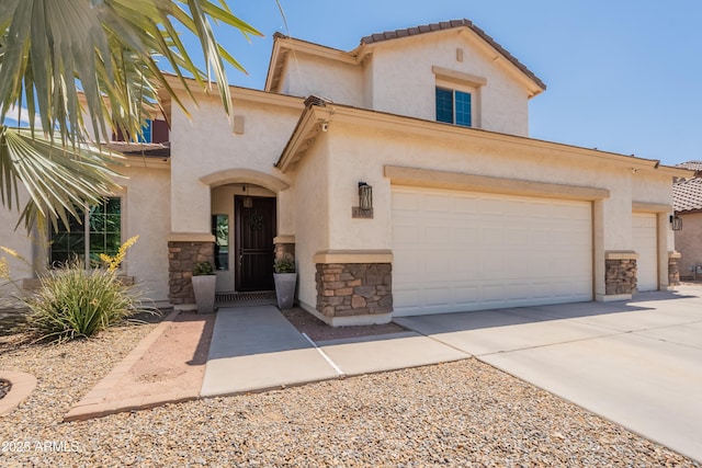 mediterranean / spanish-style house featuring stone siding, stucco siding, driveway, and a tile roof