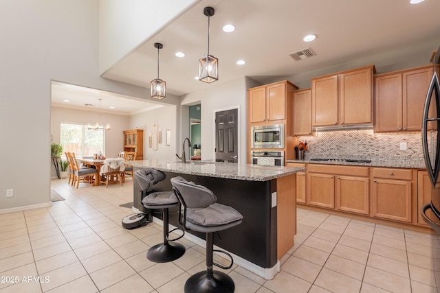 kitchen with stainless steel appliances, a sink, decorative backsplash, light stone counters, and recessed lighting