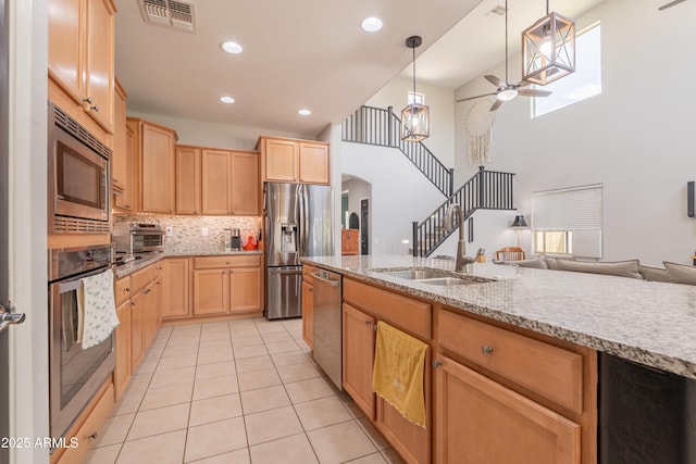 kitchen with appliances with stainless steel finishes, light brown cabinetry, light tile patterned flooring, a ceiling fan, and recessed lighting