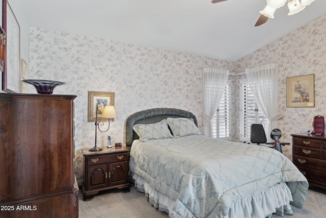 bedroom featuring wallpapered walls, light carpet, lofted ceiling, and a ceiling fan