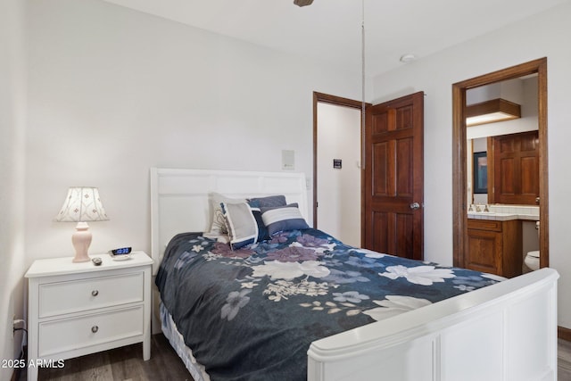 bedroom with dark wood-style floors, ensuite bathroom, and a sink