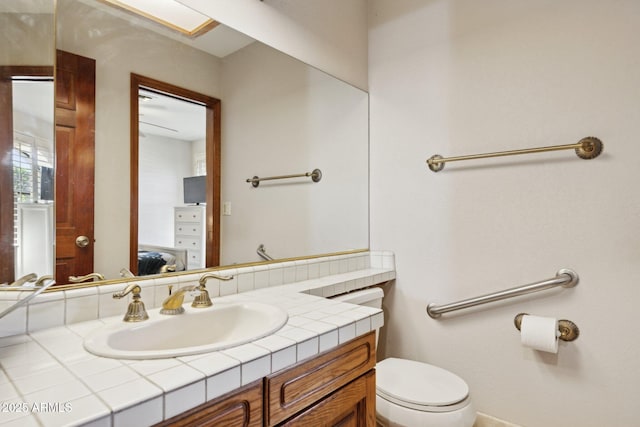 half bathroom featuring connected bathroom, toilet, and vanity