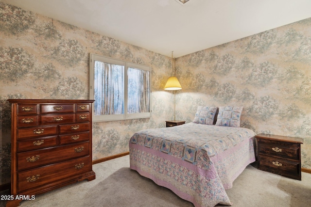 bedroom with light colored carpet, wallpapered walls, and baseboards