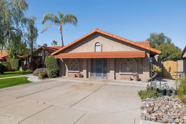 view of front of home featuring a tile roof, stucco siding, and concrete driveway