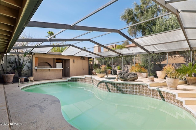 swimming pool with an outdoor kitchen, a patio, and a lanai