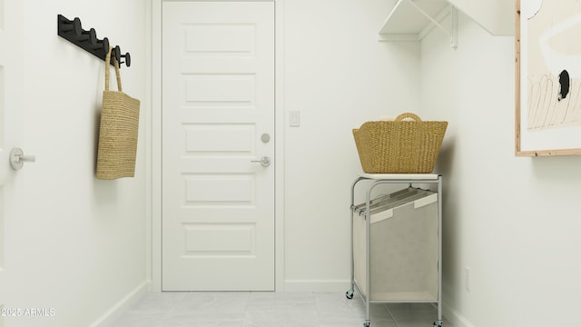 laundry room with light tile patterned flooring and baseboards