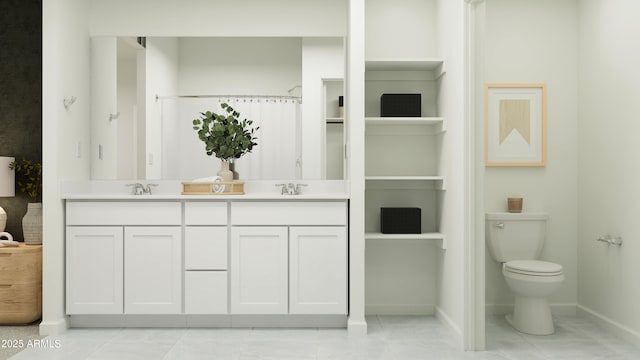 bathroom featuring toilet, double vanity, a sink, and baseboards