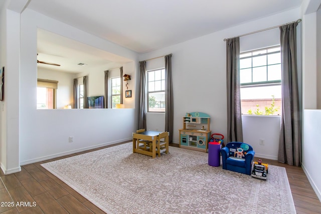 game room featuring ceiling fan, plenty of natural light, and wood-type flooring