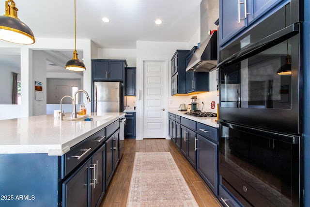 kitchen featuring a kitchen island with sink, blue cabinetry, and appliances with stainless steel finishes