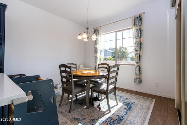 dining area featuring dark hardwood / wood-style flooring and an inviting chandelier