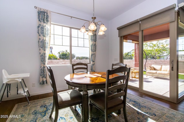 dining area featuring a notable chandelier and dark hardwood / wood-style flooring