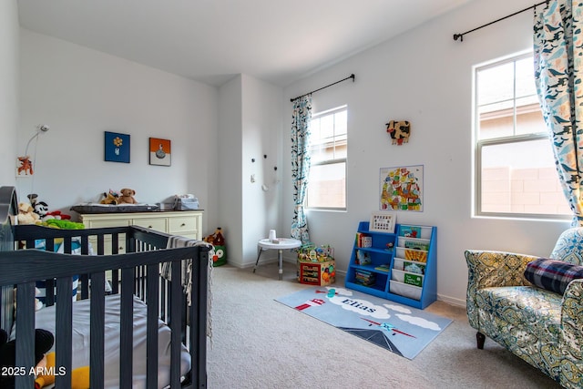 bedroom featuring multiple windows, carpet, and a nursery area