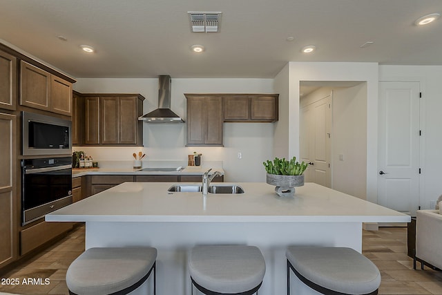 2121 W Sonoran Desert Dr Unit 86, Phoenix, AZ 85085 - kitchen with oven, wall chimney range hood, built in microwave, a kitchen breakfast bar, and recessed lighting