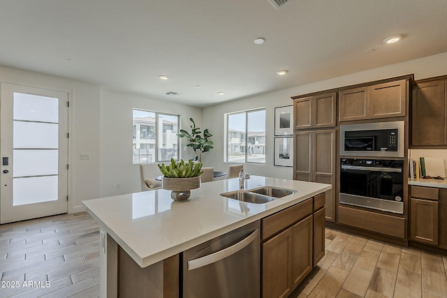 2121 W Sonoran Desert Dr Unit 86, Phoenix, AZ 85085 - kitchen with stainless steel appliances, light countertops, wood finish floors, a center island with sink, and recessed lighting