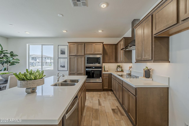 2121 W Sonoran Desert Dr Unit 86, Phoenix, AZ 85085 - kitchen featuring appliances with stainless steel finishes, light wood-type flooring, light countertops, recessed lighting, and wall chimney range hood