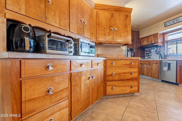 kitchen featuring light tile patterned flooring, stainless steel appliances, and a textured ceiling