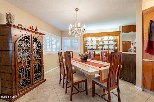 dining space featuring light tile patterned floors, an inviting chandelier, and a textured ceiling