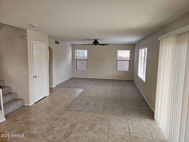 4613 W Fawn Dr, Laveen, AZ 85339 - spare room with visible vents, ceiling fan, stairway, light colored carpet, and light tile patterned floors