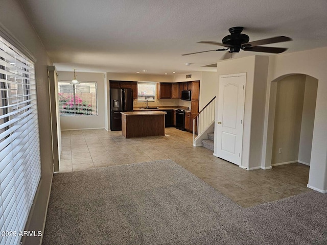 4613 W Fawn Dr, Laveen, AZ 85339 - kitchen featuring light tile patterned floors, a kitchen island, black appliances, and a sink