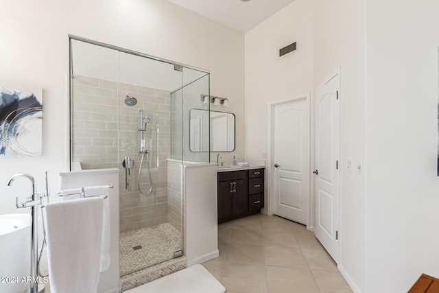 bathroom with tile patterned flooring, vanity, and a shower with door