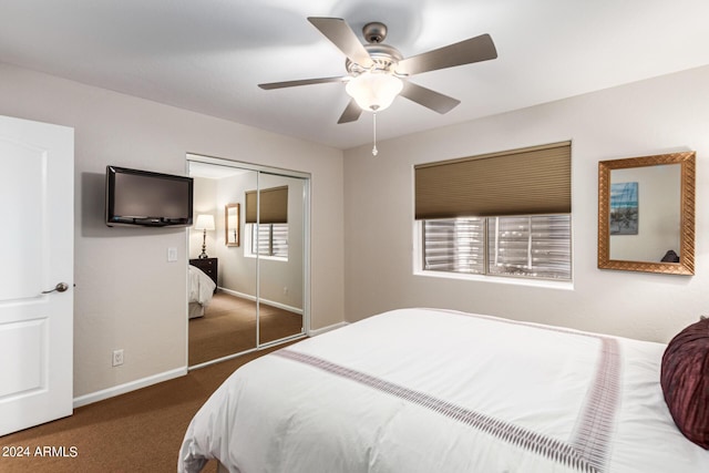 bedroom with dark colored carpet, ceiling fan, and a closet