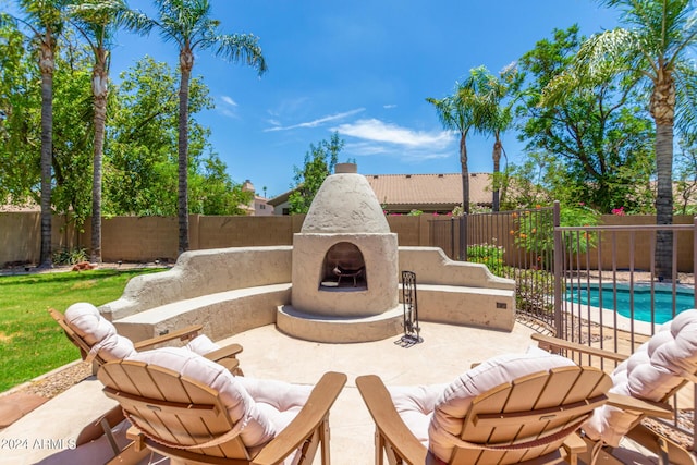 view of patio featuring a fenced in pool and an outdoor fireplace