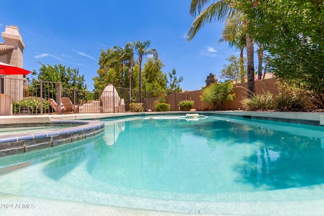 view of swimming pool with an in ground hot tub