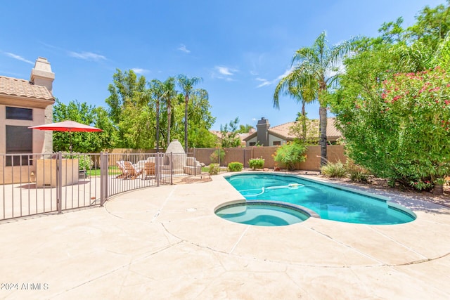 view of swimming pool with an in ground hot tub and a patio area