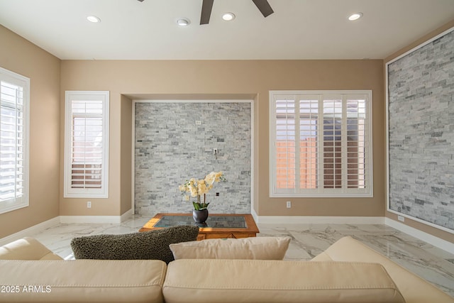 living area featuring marble finish floor, an accent wall, baseboards, and recessed lighting