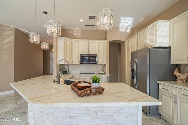 kitchen with arched walkways, marble finish floor, stainless steel appliances, visible vents, and a sink