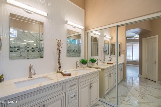 bathroom featuring double vanity, marble finish floor, and a sink