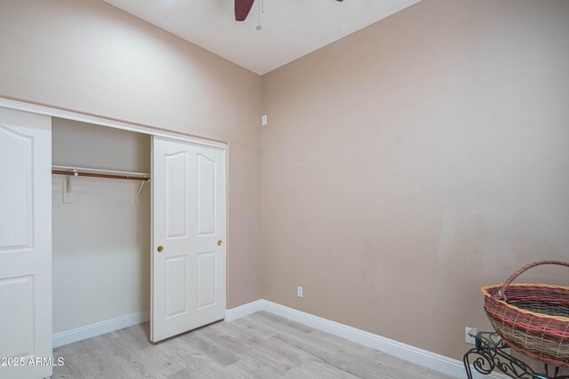 unfurnished bedroom featuring light wood finished floors, a closet, a ceiling fan, and baseboards