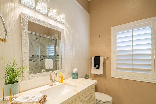 bathroom featuring vanity, a shower stall, and toilet