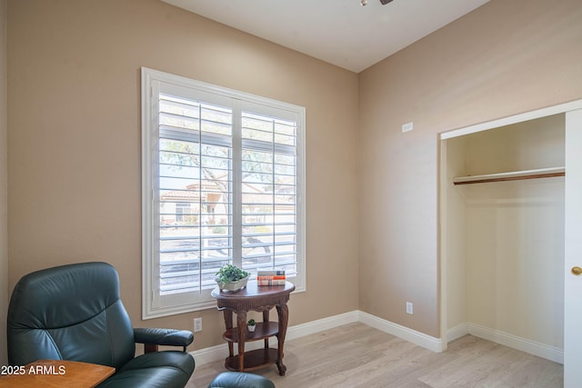 sitting room with light wood-style flooring, a wealth of natural light, and baseboards