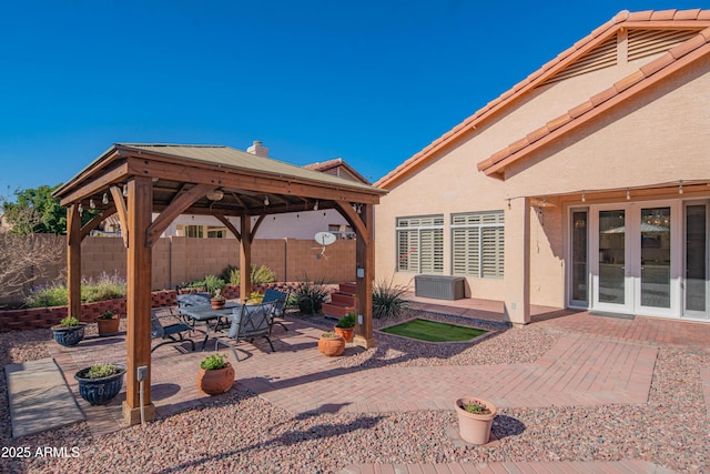 view of patio / terrace with french doors, fence, and a gazebo