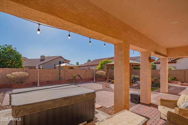 view of patio / terrace with a hot tub and a fenced backyard