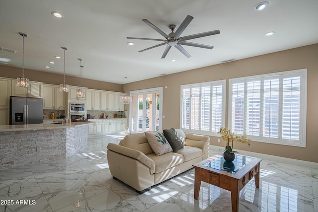 living area with marble finish floor, visible vents, and recessed lighting