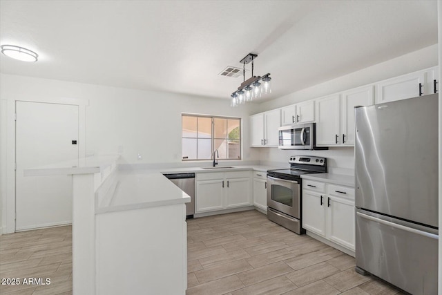 1510 W Fillmore St, Phoenix, AZ 85007 - kitchen featuring appliances with stainless steel finishes, a peninsula, light countertops, and white cabinets